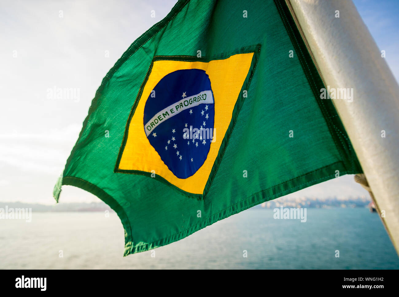 Golden Hintergrundbeleuchtung Blick auf dicke texturierte Flagge von Brasilien fliegen im Freien in tropischen brasilianischen Sonnenlicht Stockfoto