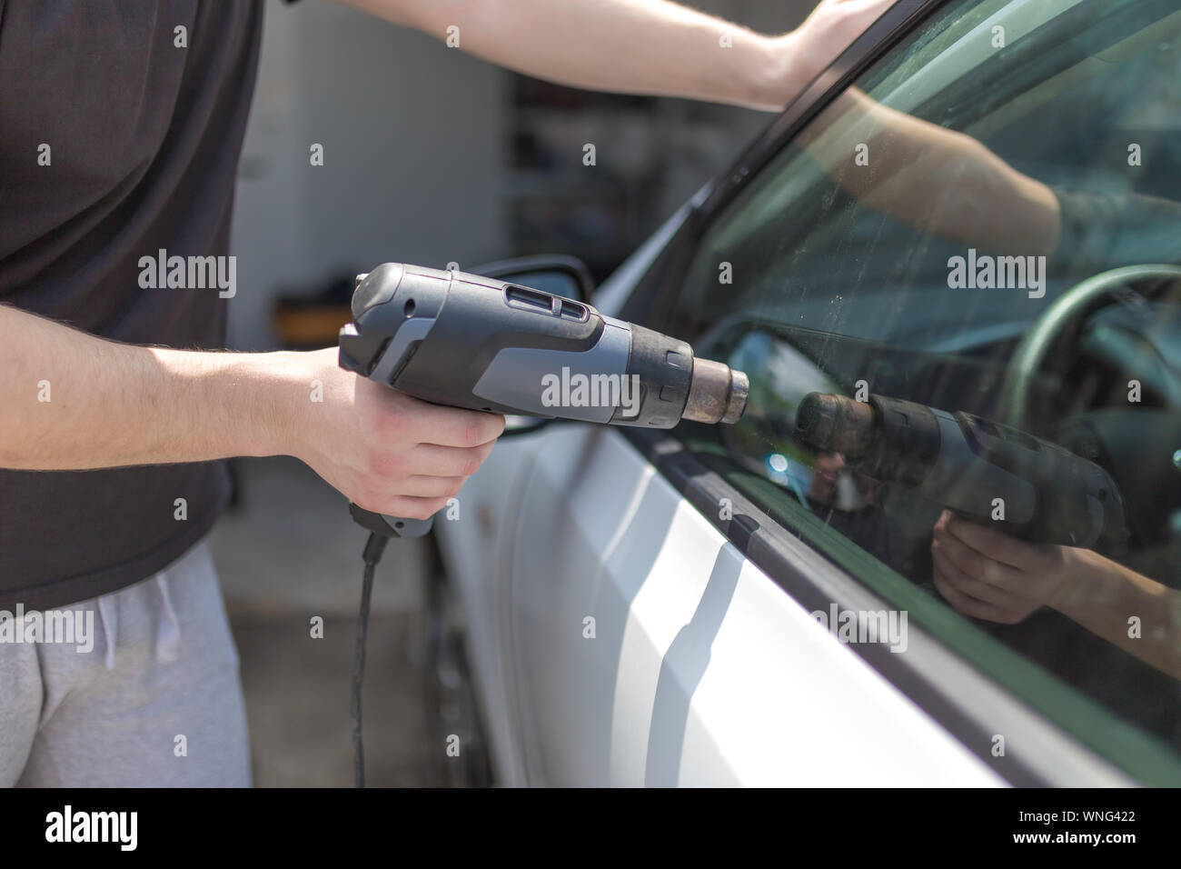 Mitarbeiter entfernen Auto Fensterfolie Folie mit Heißluftpistole