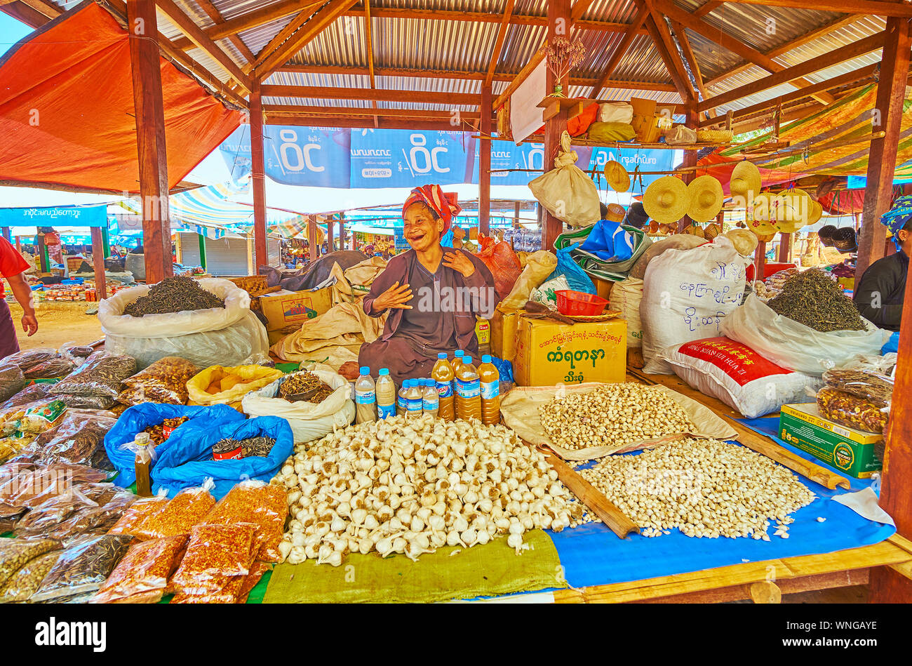 KAKKU, MYANMAR - Februar 20, 2018: Ältere Menschen markt anbieter von Pa-Oh ethnische Gruppe ist loughing und für Porträt posieren, unter verschiedenen Agri sitzen Stockfoto