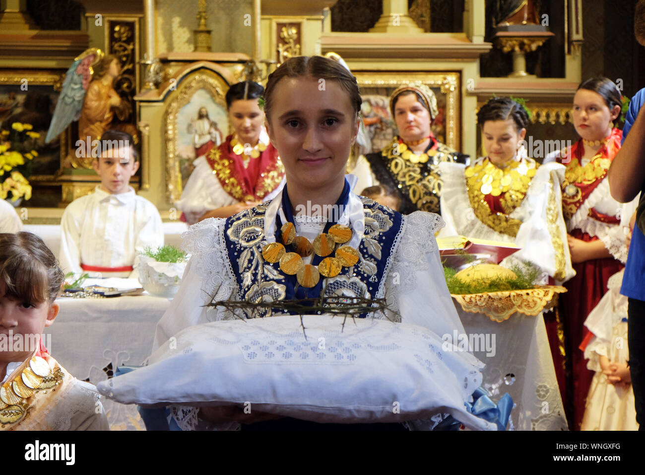 Girl holding Dornenkrone in der traditionellen regionalen Trachten in der  Kirche bei der Messe gekleidet am Thanksgiving Tag in Stitar, Kroatien  Stockfotografie - Alamy