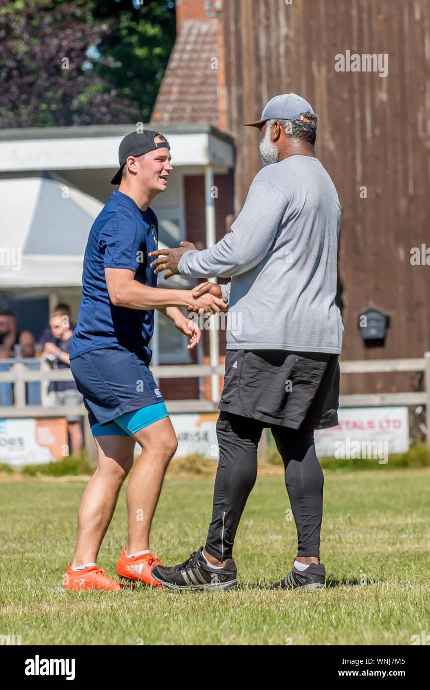 Amateur Rugby touch Player (Mann, 20-30 J.) schüttelt Hände mit älteren männlichen Gegner am Ende des Spiels, die den Geist der Freundschaft im Rugby Stockfoto