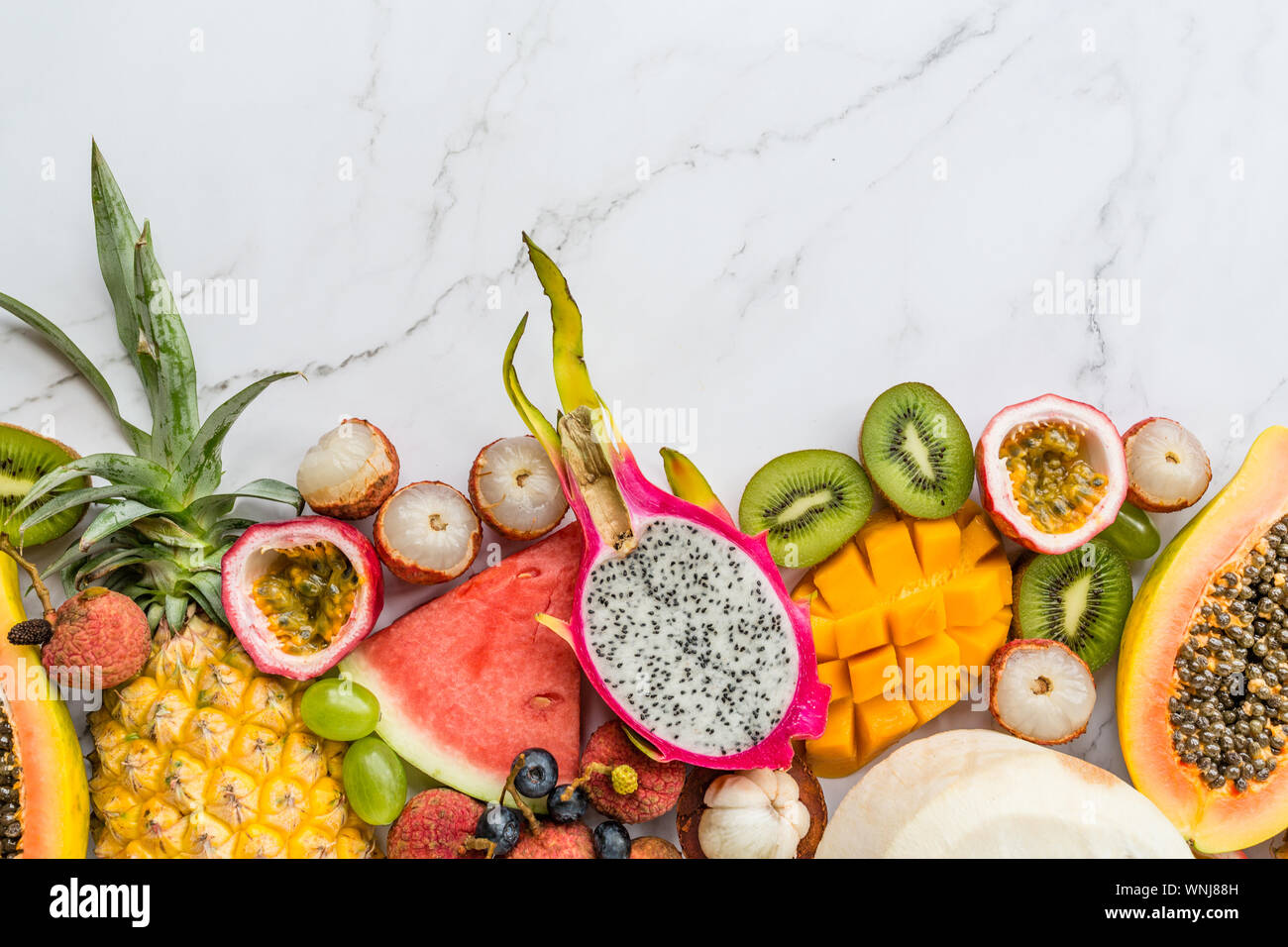Frische exotische Früchte und tropischen Palmen Blätter auf weißem Hintergrund - Papaya, Mango, Ananas, Maracuja, Drachenfrucht, Melone. Mockup, flach Stockfoto