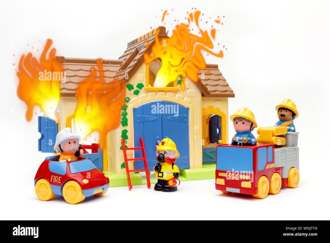 Spielzeug Feuerwehr Bekämpfung ein Spielzeug, das auf Feuer, mit Flammen  aus den Fenstern, Schuß auf weißem Hintergrund Stockfotografie - Alamy