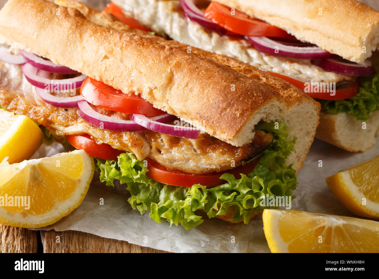 Fast food Sandwich balik ekmek mit gegrillten Makrelen mit Zitrone Nahaufnahme auf dem Tisch serviert. Horizontale Stockfoto