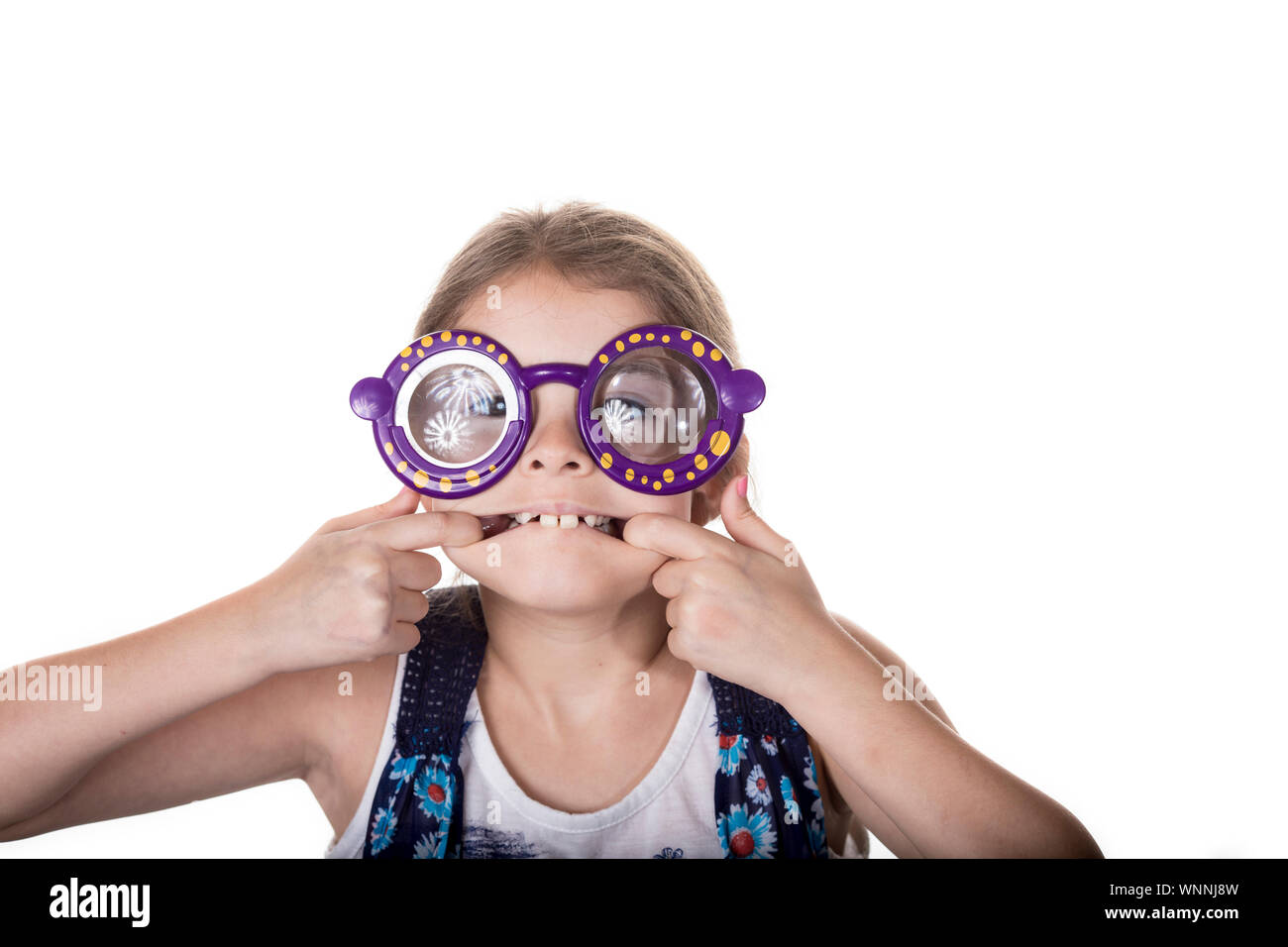 Kleines Mädchen, dummes Gesicht mit bunten Spielzeug Gläser. Stockfoto