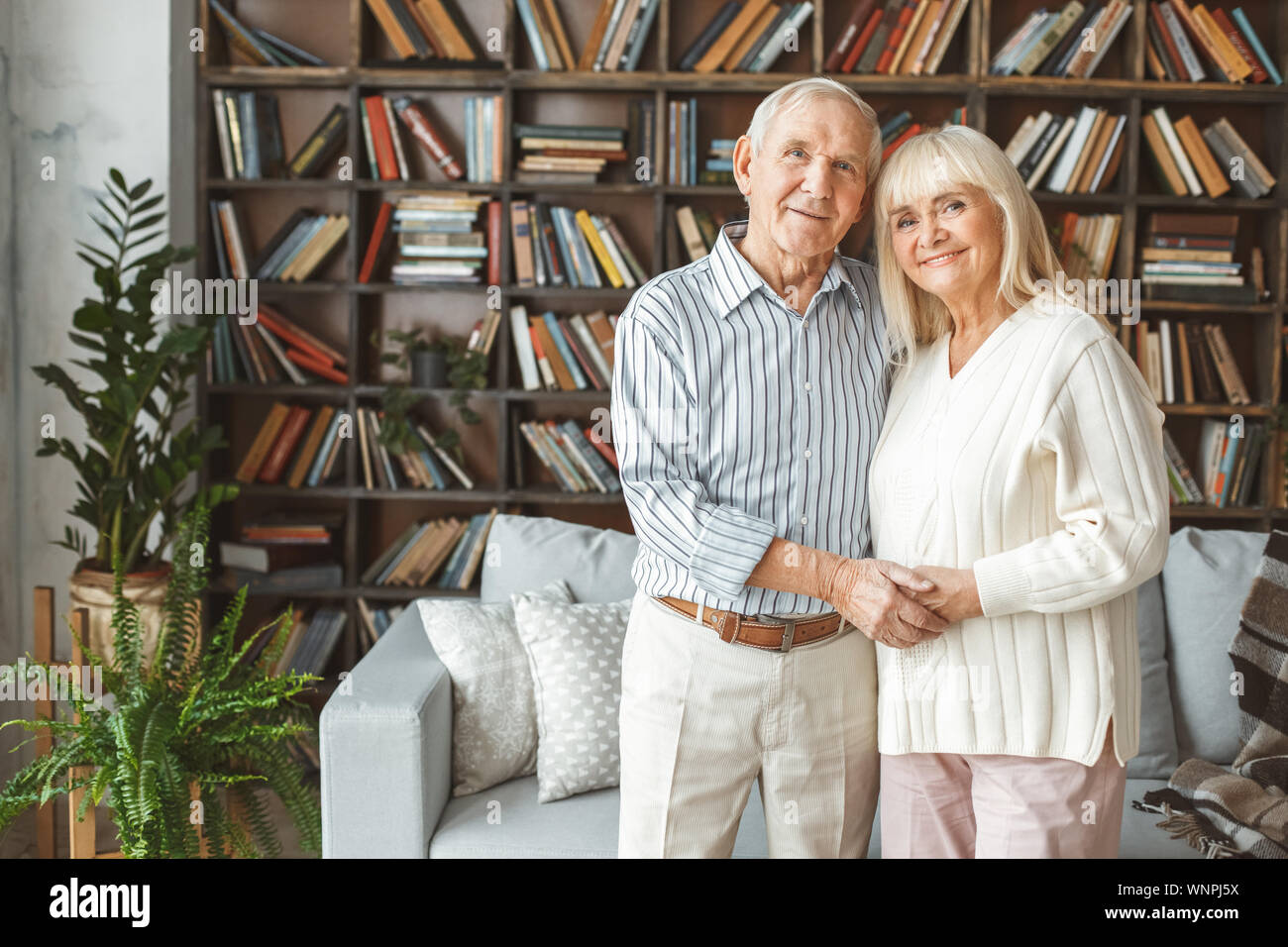 Senior Paar zusammen zu Hause Ruhestand Konzept stand halten sich an den Händen umarmt Stockfoto