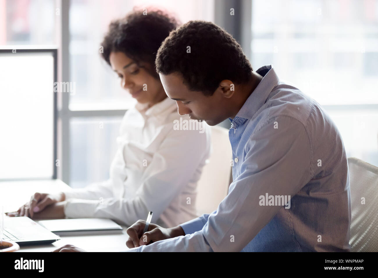 Afrikanische amerikanische Manager schreiben bewerten Trainee Praktikum Ergebnisse Stockfoto