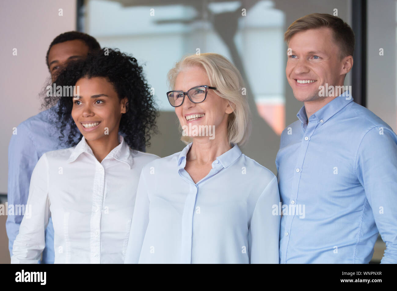 Motivierte Mitarbeiter suchen in Distanz zum Gruppenfoto posiert Stockfoto