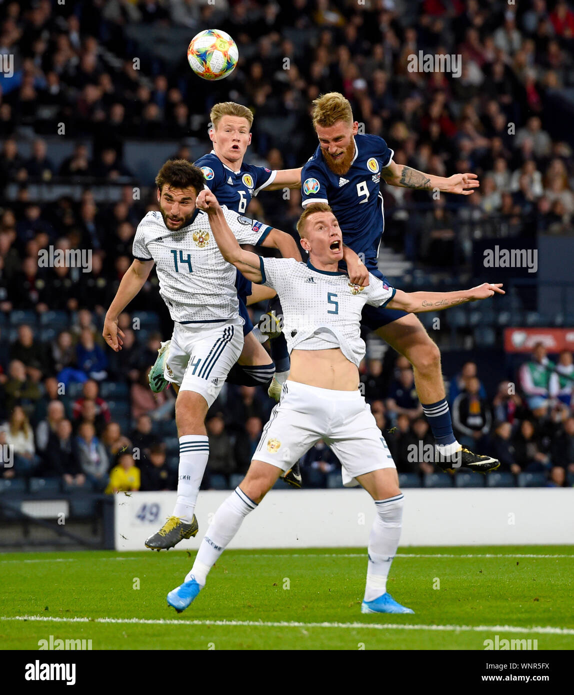 Russlands Georgij Dzhikija (links) und Andrei Semenov (vorne) Kampf um den Ball in der Luft mit dem schottischen Scott McTominay und Oliver McBurnie während der UEFA EURO 2020 Qualifikation, Gruppe I am Hampden Park, Glasgow entsprechen. Stockfoto