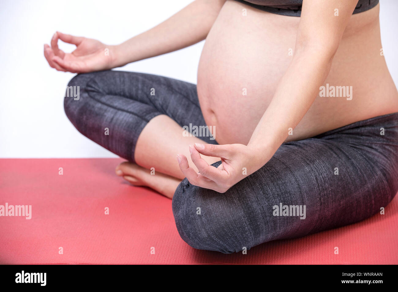 Zukunft junge Mutter übung Yoga. Schöne schwangere Frau meditieren Stockfoto