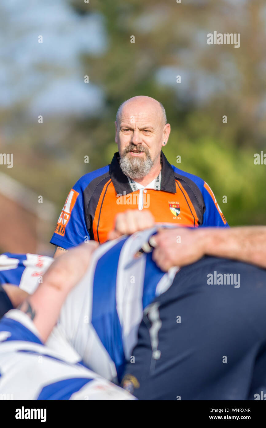 Norfolk Schiedsrichter Gesellschaft Schiedsrichter übernimmt die Kontrolle über die Scrum bei einem amateur Rugby-spiel Stockfoto