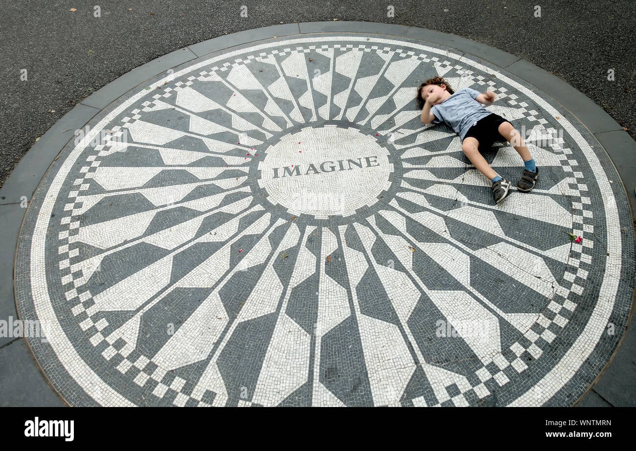 Ein Kind spielt auf dem Strawberry Fields Monument für John Lennon im Central Park, New York Stockfoto