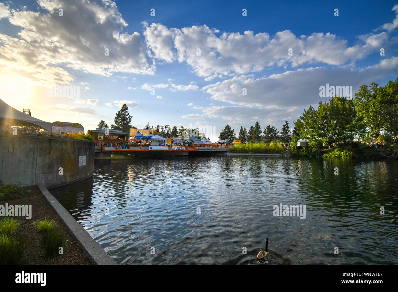 Die Sonne beginnt in der Abenddämmerung über dem Zelte, Stände und Anbietern bei der jährlichen Schwein im Park an der Riverfront Park in Spokane, Washington, USA einstellen Stockfoto
