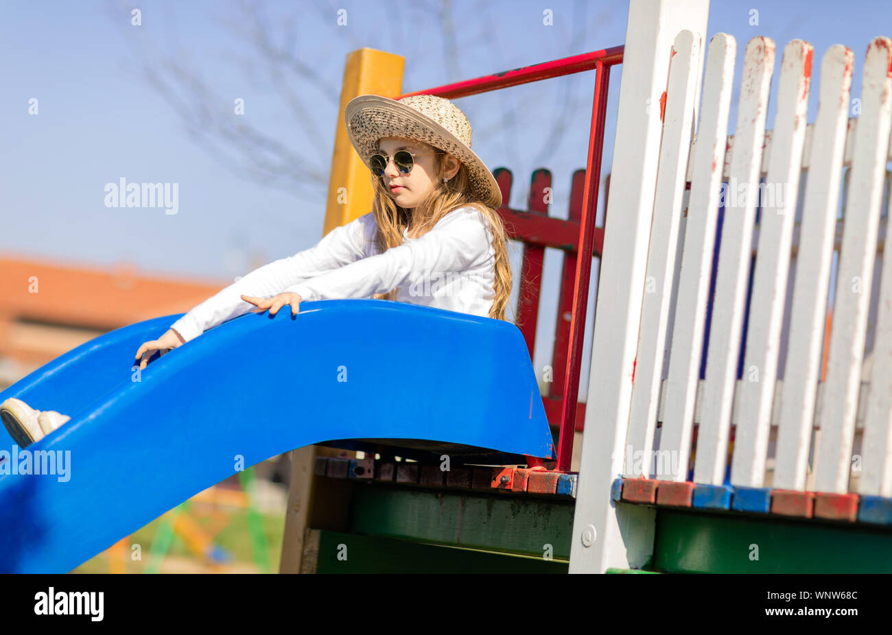 Junge hipster Mädchen mit Sonnenbrille und Hut auf dem Spielplatz Stockfoto