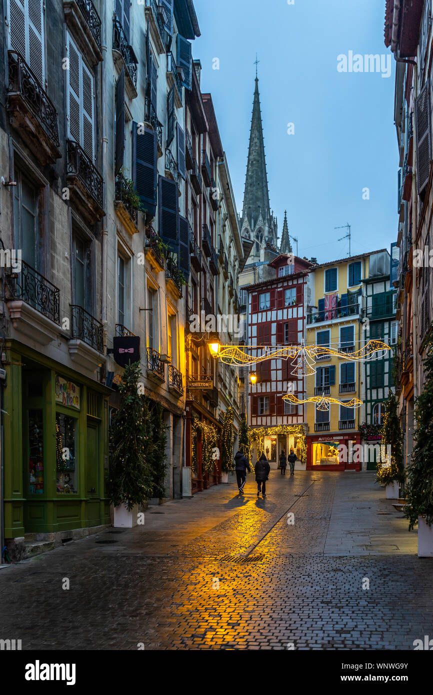 Eine typische Straße mit Kopfsteinpflaster in der Altstadt von Bayonne während der Weihnachtszeit beleuchtet führende, Frankreich Stockfoto