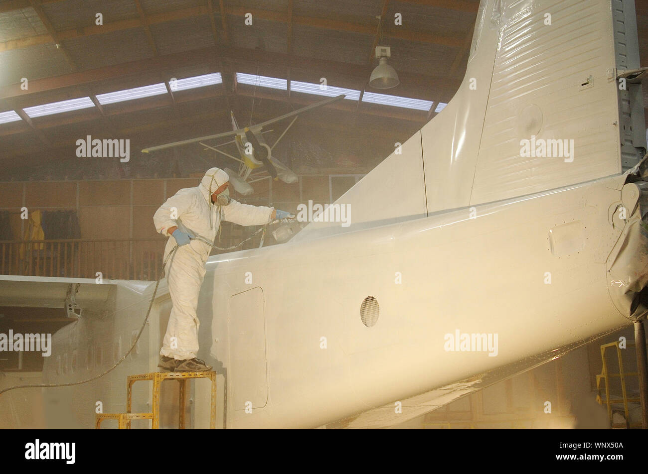 Handwerker Sprays der Rumpf auf eine Dornier 228 Flugzeugen Stockfoto