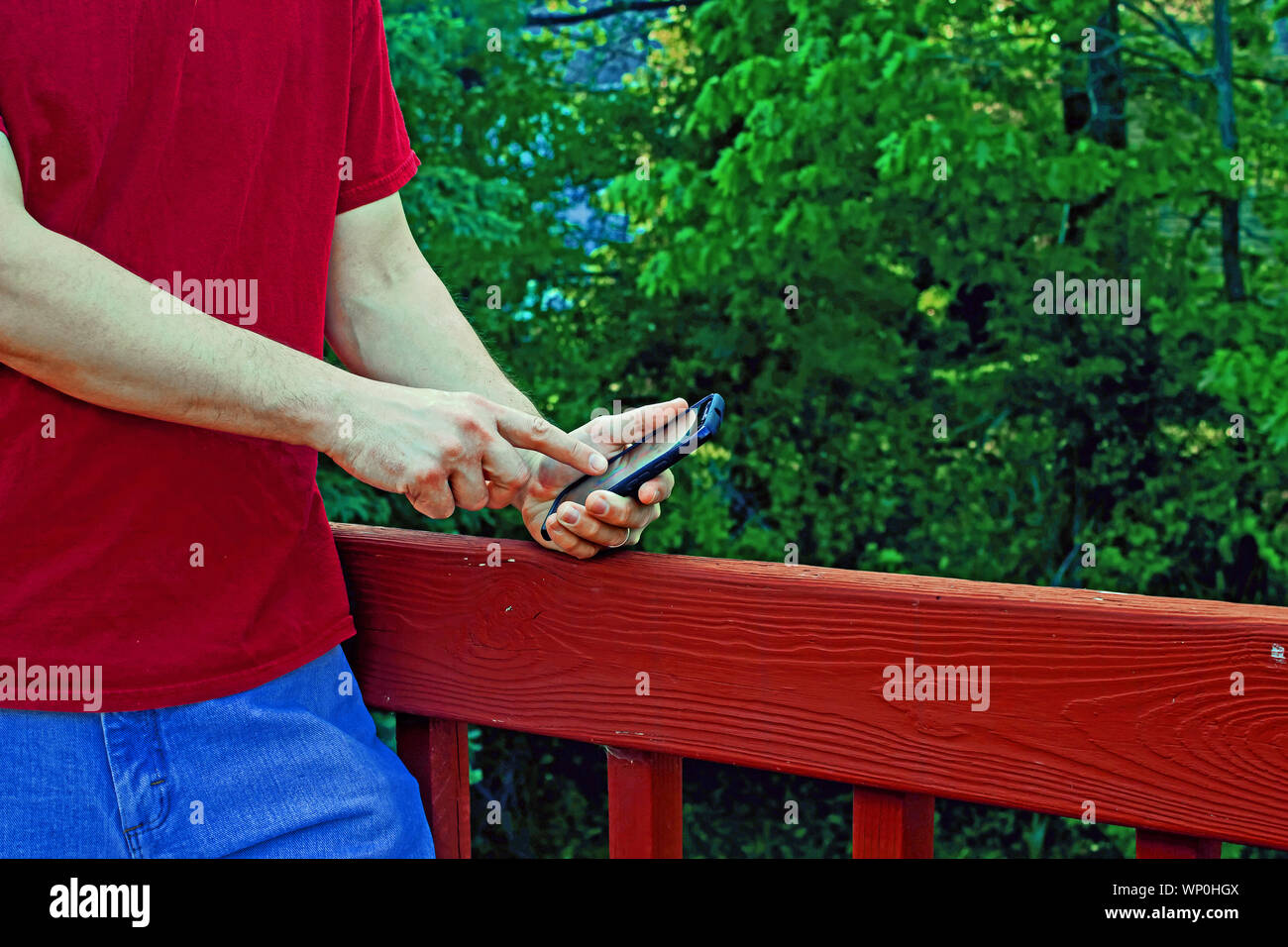 Man sendet eine Textnachricht auf Smart Phone in ländlicher Umgebung Stockfoto