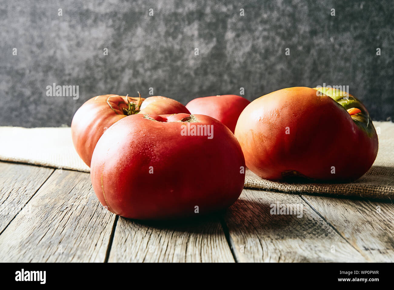 Farbenfroh, frisch, große homegrown Tomaten auf einem alten Holztisch. Die Ernte. Stockfoto