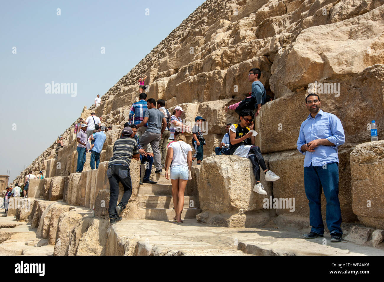 Besucher der Pyramiden von Gizeh bei Kairo in Ägypten Aufstieg über die riesigen sandsteinblöcken der Cheops-pyramide. Stockfoto