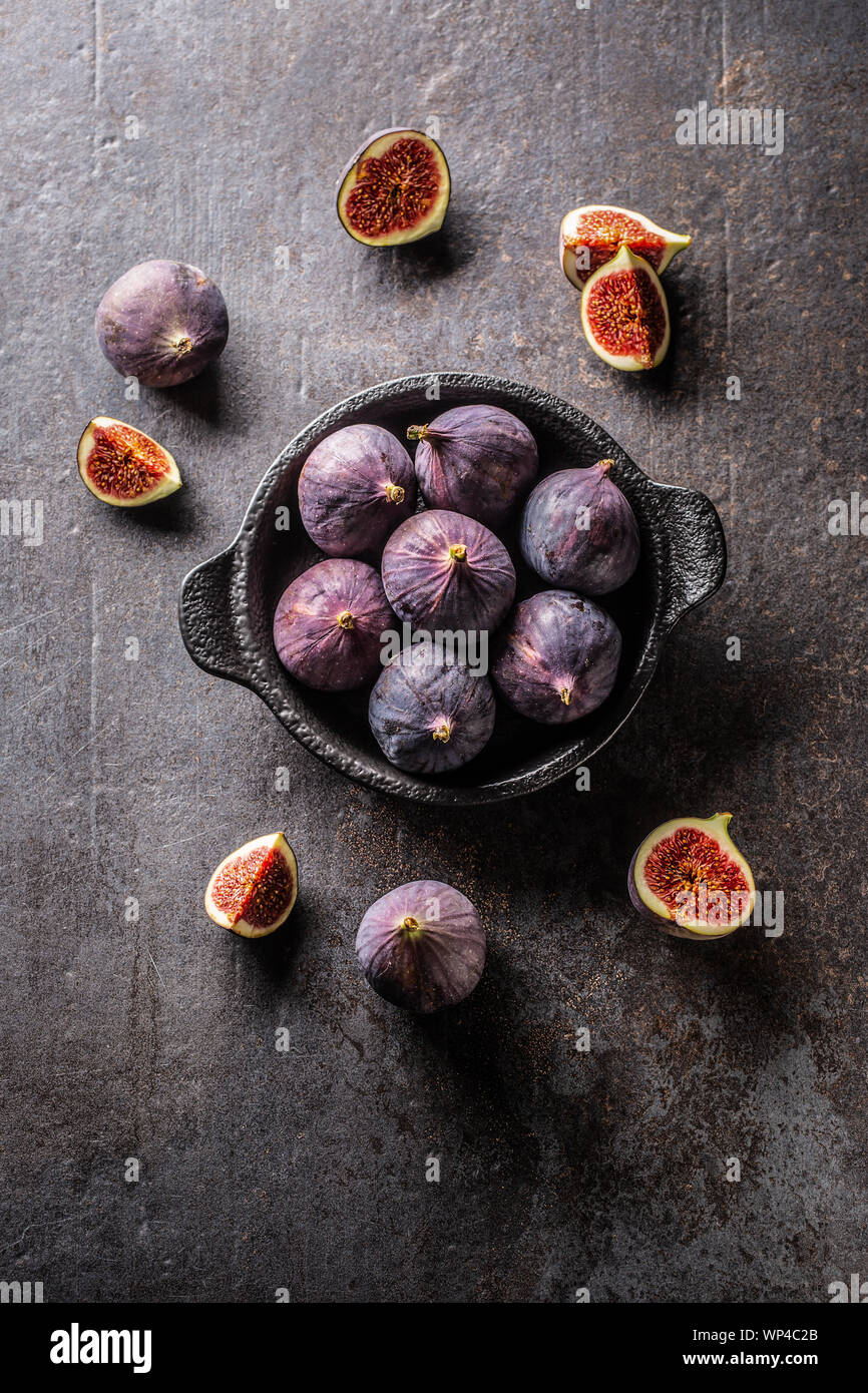 Ein paar Feigen in einem schwarzen Schüssel auf eine dunkle konkrete table-top Sicht Stockfoto