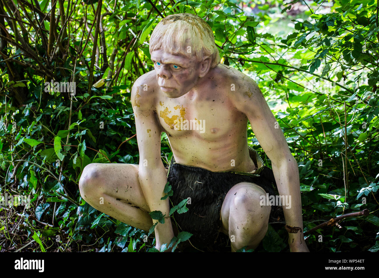 Ein Kunststoff Modell des Neandertalers im Waldland Szene bei Wookey Hole, Somerset, Großbritannien Stockfoto