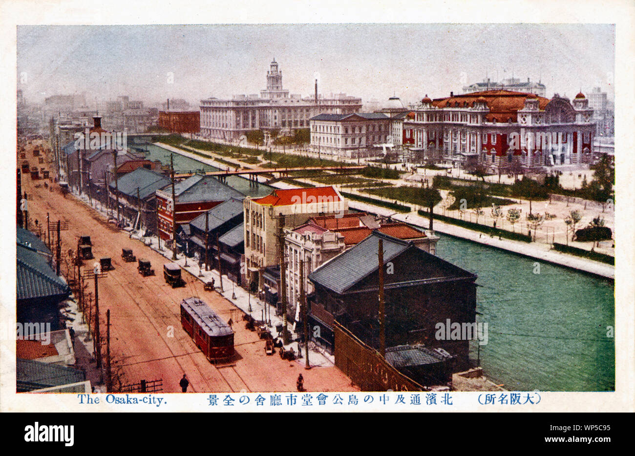 [1920s Japan - TITEL] - Diese Postkarte aus den 1920er Jahren zeigt eine Strassenbahn in Osakas Geschäftsviertel von kitahama und der örtlichen Regierung Sitz auf Nakanoshima, eine Insel zwischen den Dojima und Tosabori Flüsse eingeklemmt. Osaka wurde bereits gründlich modernisiert. Das rot eingefärbte stattliche Gebäude mit dem orange Dach ist die Osaka Central Public Hall. Dahinter verbirgt sich die Prefectural Library und hinter dem Rathaus Osaka. 20. jahrhundert alte Ansichtskarte. Stockfoto