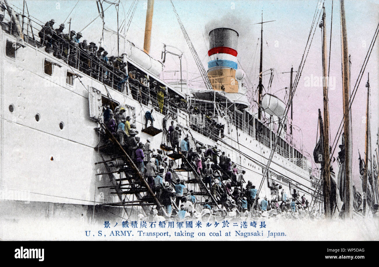 [1910s Japan - Coaling a US Army Transportschiff in Nagasaki] - eine Masse der Hafenarbeiter laden hochwertige Kyushu Kohle auf eine US-Armee Transportschiff in Nagasaki. Sobald Schiffe eingetragen Hafen von Nagasaki, Hunderte von Männern, Frauen, Jungen und Mädchen um sie herum, auf die Kohle Lastkähne umschwärmt, temporäre Bauten, und begann die hungrigen Schiffe mit Kohle zu laden. 20. jahrhundert alte Ansichtskarte. Stockfoto