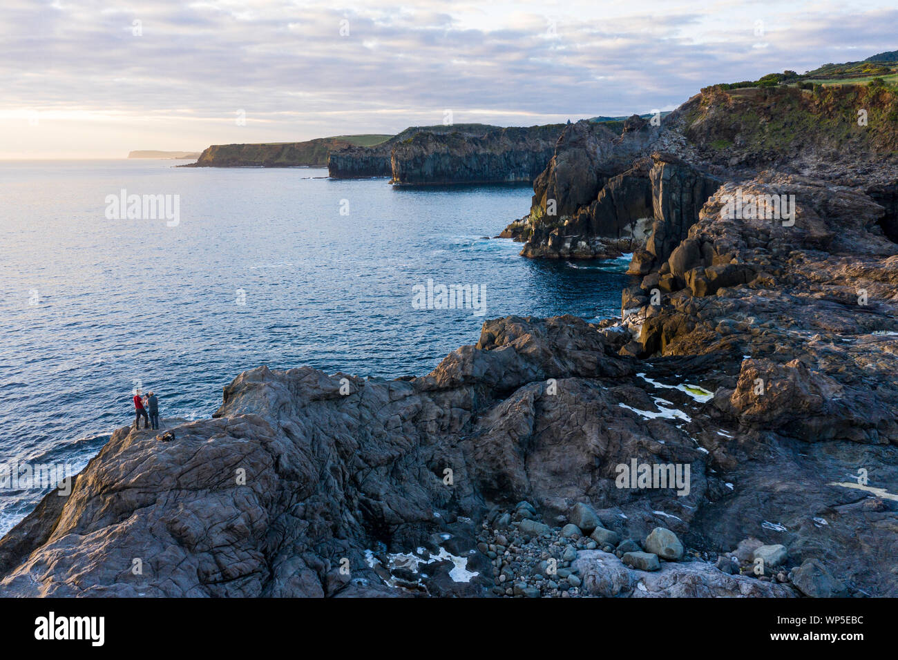 Zwei Fotografen die Bilder von den Sonnenaufgang an der felsigen Küste von Ponta do Mistério auf Terceira Insel der Azoren. Am Morgen Licht hits Gi Stockfoto
