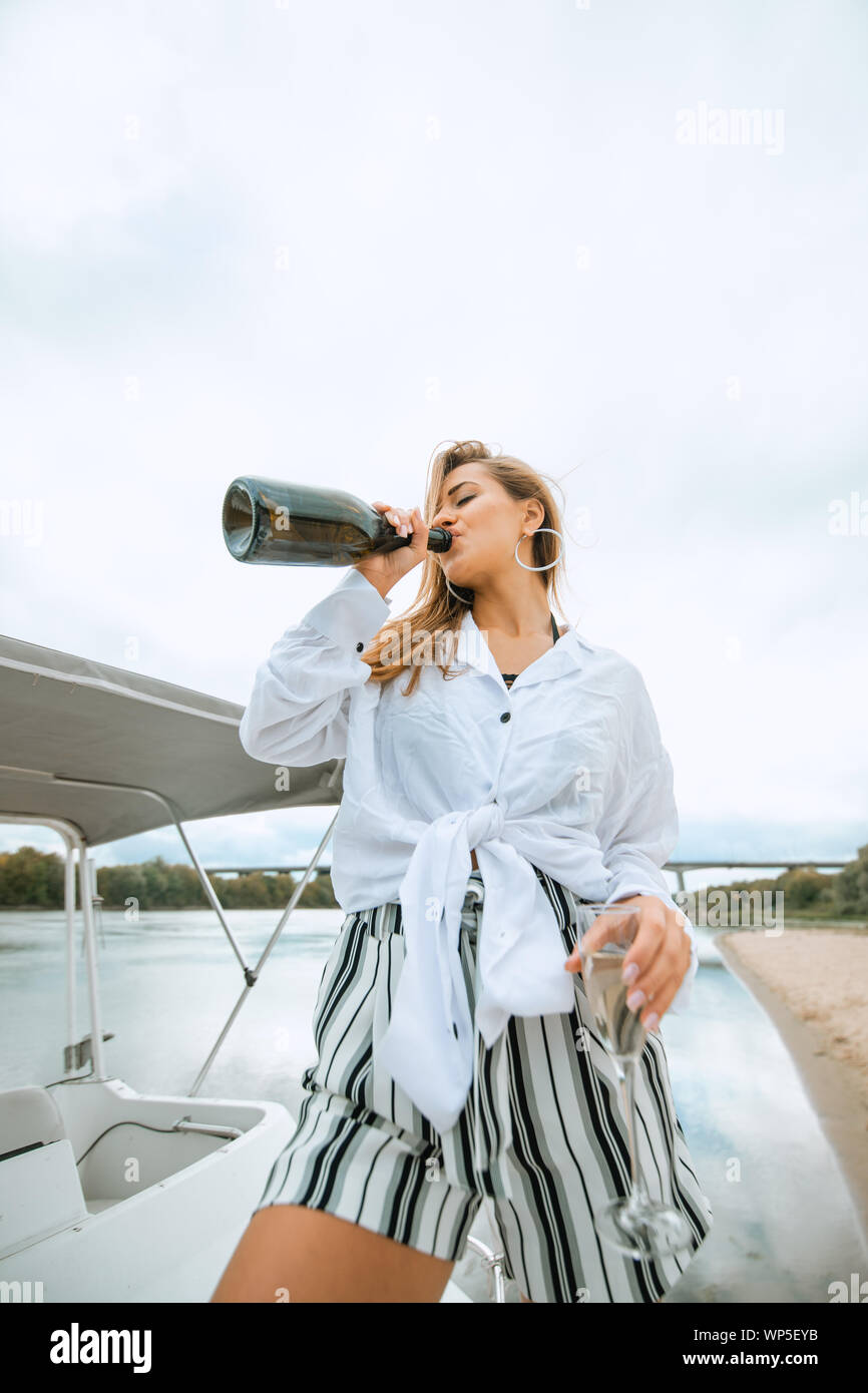 Ein luxuriöses reiche Frau funs Yacht und Getränke Champagner Stockfoto