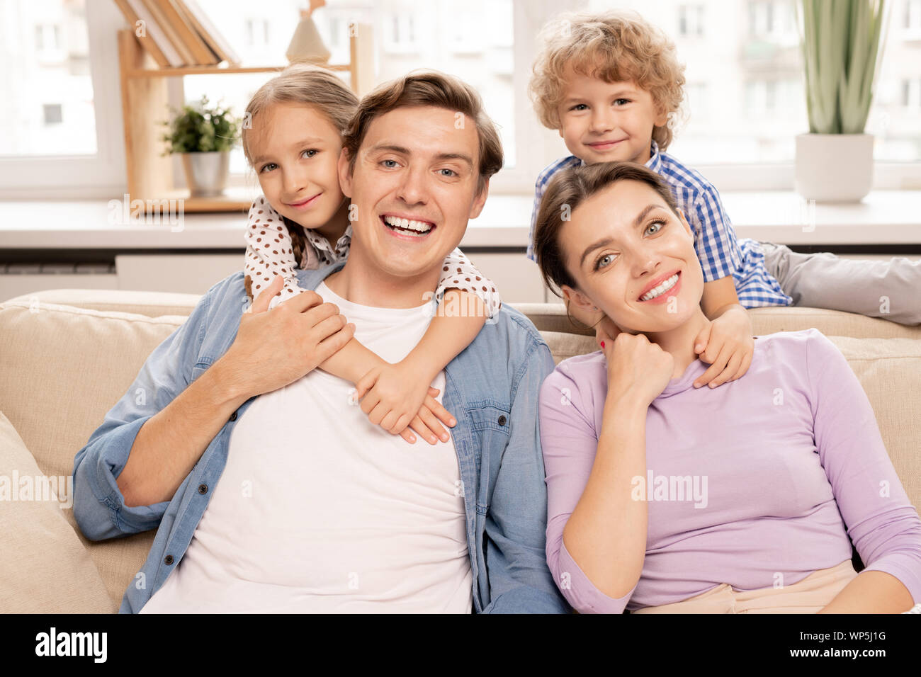 Junge fröhliche Familie von Vater, Mutter und zwei süße Geschwister Stockfoto