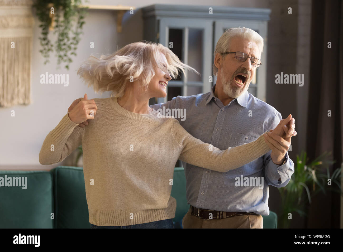 Aktives glückliches junges Paar Spaß am Tanzen zu Hause Stockfoto