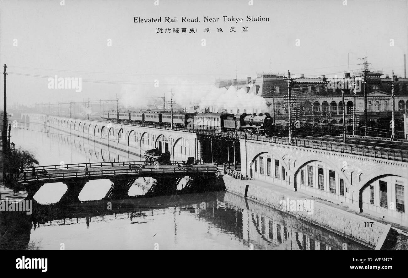 [1910s Japan - Hochbahn Titel in Tokio] - eine Dampflok zieht Pkw auf erhöhten Schienen in der Nähe der Tokyo Station in Tokio. Auf der Rückseite, der Teikoku Hotel (Hotel Imperial) gesehen werden kann. Es eröffnet am 20. November 1890. Das Hotel wurde durch einen Brand am 16. April 1922 zerstört. Am 1. September 1923, eine neue Teikoku Hotel, entworfen von Frank Lloyd Wright, eröffnet. Das Gebäude wurde 1968 abgerissen. 20. jahrhundert alte Ansichtskarte. Stockfoto