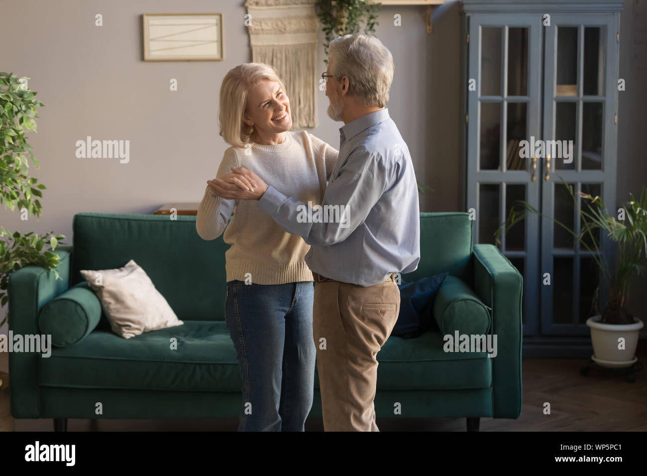 Lächelnde ältere Ehepartner Tanz zu Hause waltzing Stockfoto