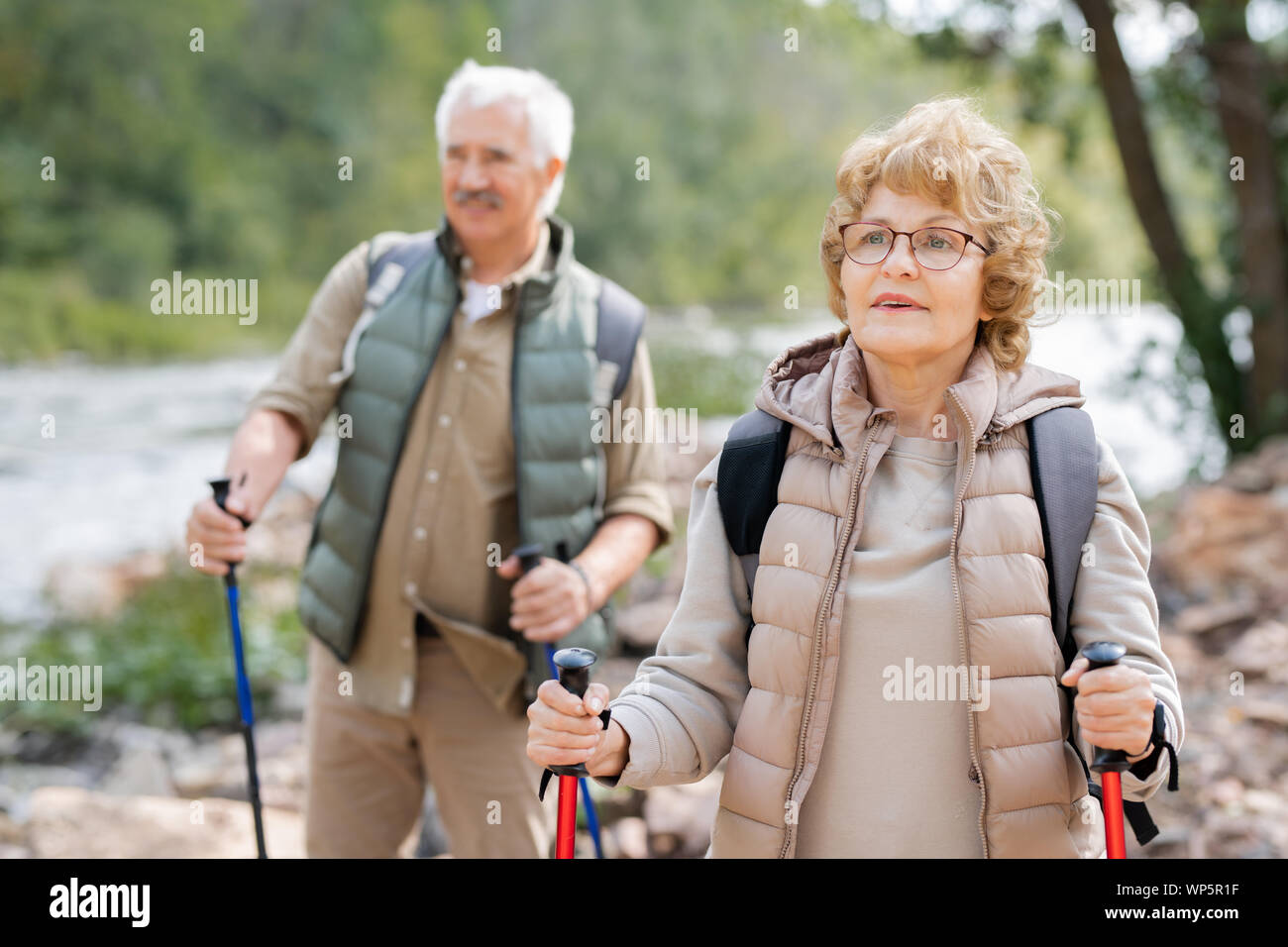 Hübsche reife weibliche Wanderer und ihr Mann nach unten bewegt River Bank Stockfoto