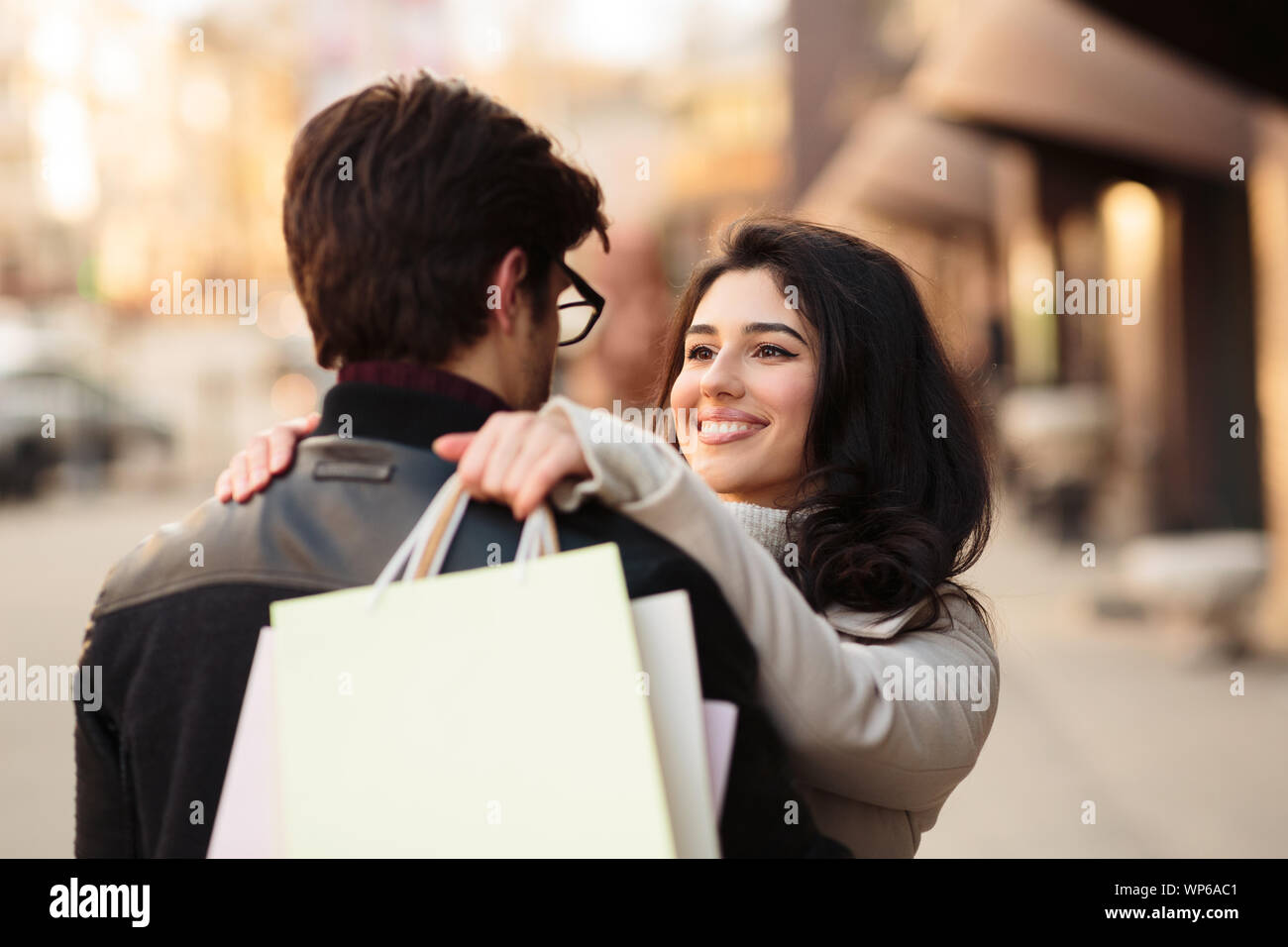 Erfolgreiche Geschäfte. Aufgeregt Frau umarmt Ehemann nach dem Einkaufen Stockfoto