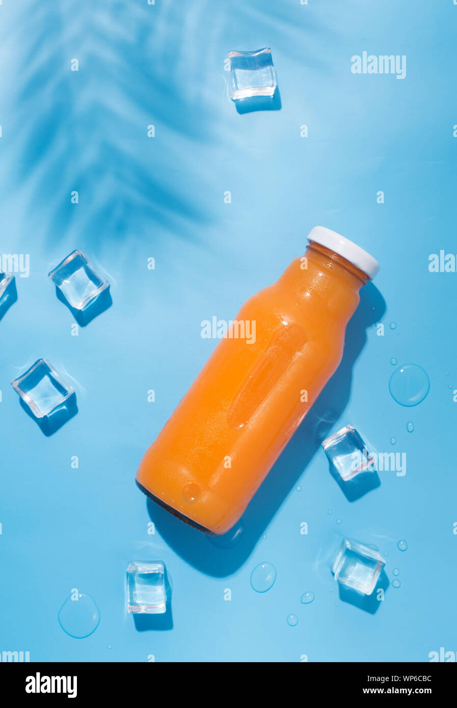 Sommer gesund detox orange Drink mit Eiswürfeln auf Blau Stockfoto