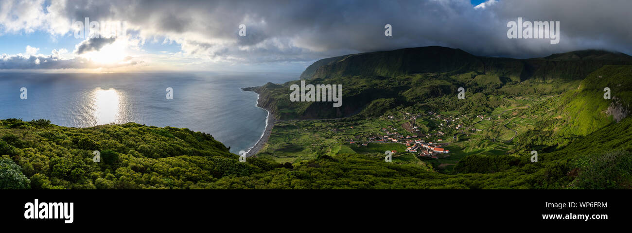 Panorama Landschaft bei Sonnenuntergang von miradouro do Portal mit Blick auf das Dorf Fajãzinha und Adeia da cuada mit Fajã Grande und dem grünen Felsen Stockfoto