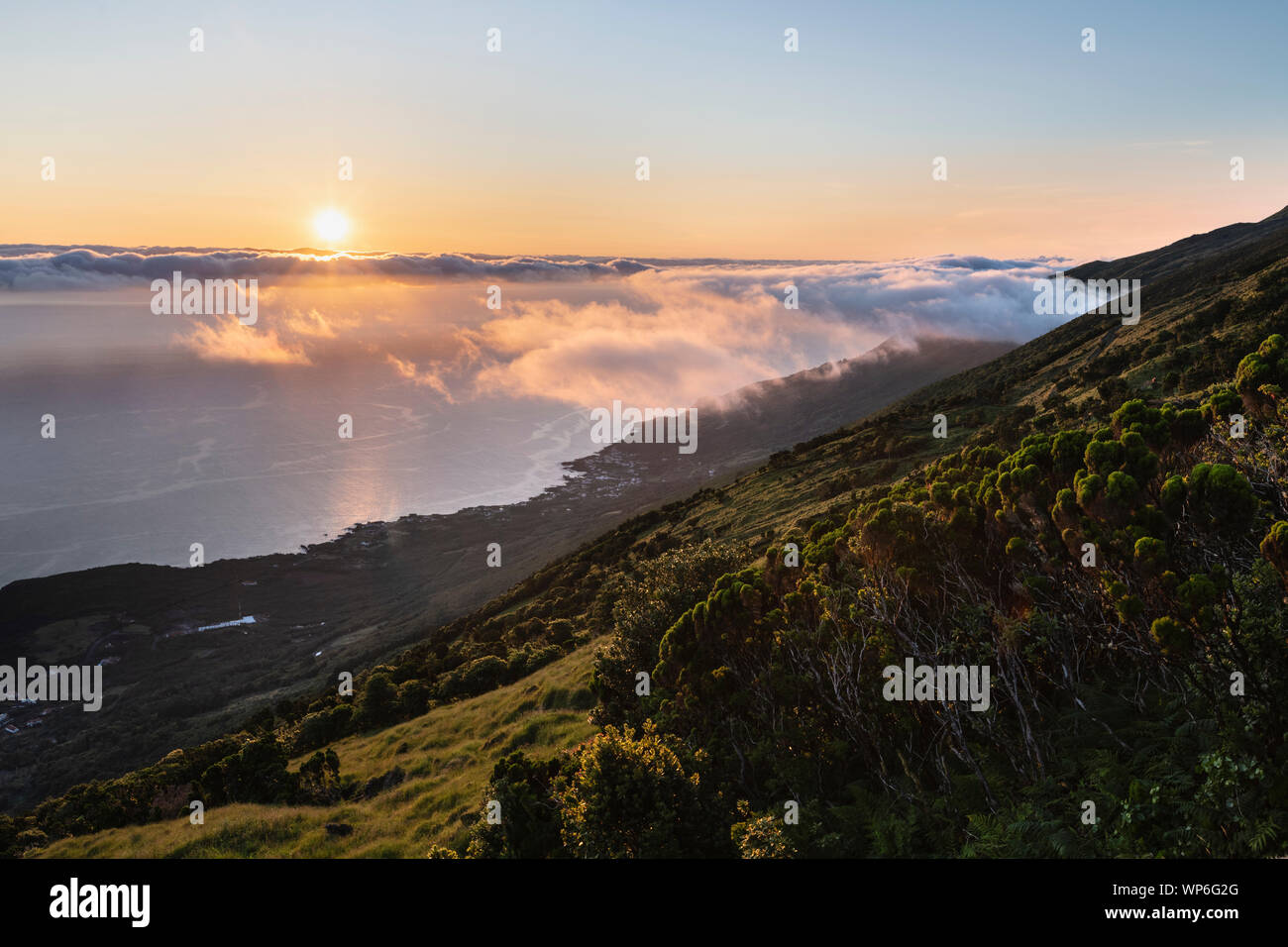 Sunrise Landschaft an der Nordostküste der Insel Pico, Ilha do Pico, mit Insel Sao Jorge im Hintergrund und die Küste mit Prainha do Baix Stockfoto