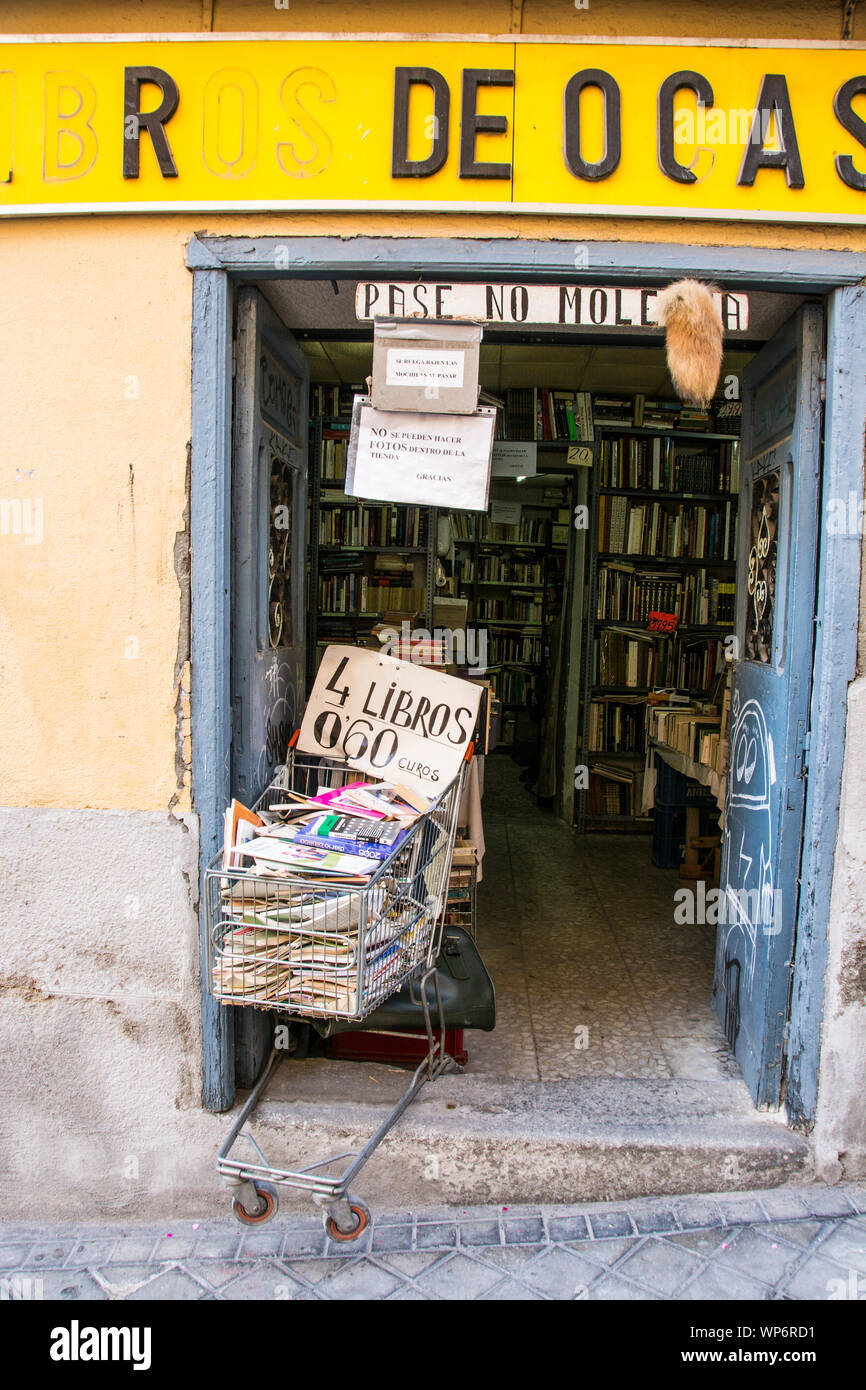 Ein Einkaufswagen am Eingang eines Buchladens in Toledo, Spanien, gefüllt bis zum Rand mit Büchern und anderen Zeitschriften. Stockfoto