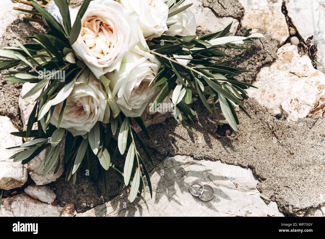 Brautstrauß aus weißen Pfingstrose Rosen und Ringe in der Nähe. Hochzeit Attribute oder Zubehör. Stockfoto