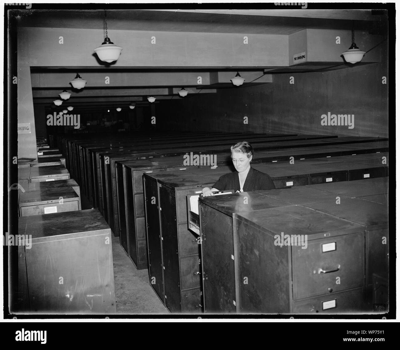 Letzte der N.R.A. Washington, D.C., Okt. 26. Frau Mildred S. Steinmetz, der 1933 als Registratur Chief mit 135 Mitarbeitern begann, ist nun alleiniger Chef Der verstorbene National Recovery Administration. Im Vergleich zu 5400 Mitarbeiter auf NRW Gehaltsabrechnung auf einmal, Miss Steinmetz hat zusammen mit nur sieben Assistenten zu erhalten, in der sie sich um die Hälfte ein Hektar Aktenschränke bis an die Grenze mit 40.000.000 Stücke von Korrespondenz, Berichte, Studien und andere Daten zu helfen. Von Zeit zu Zeit, Universitäten, Bibliotheken, Zeitungen, Branchen, und fast jede Abteilung der Regierung Anruf auf Stockfoto