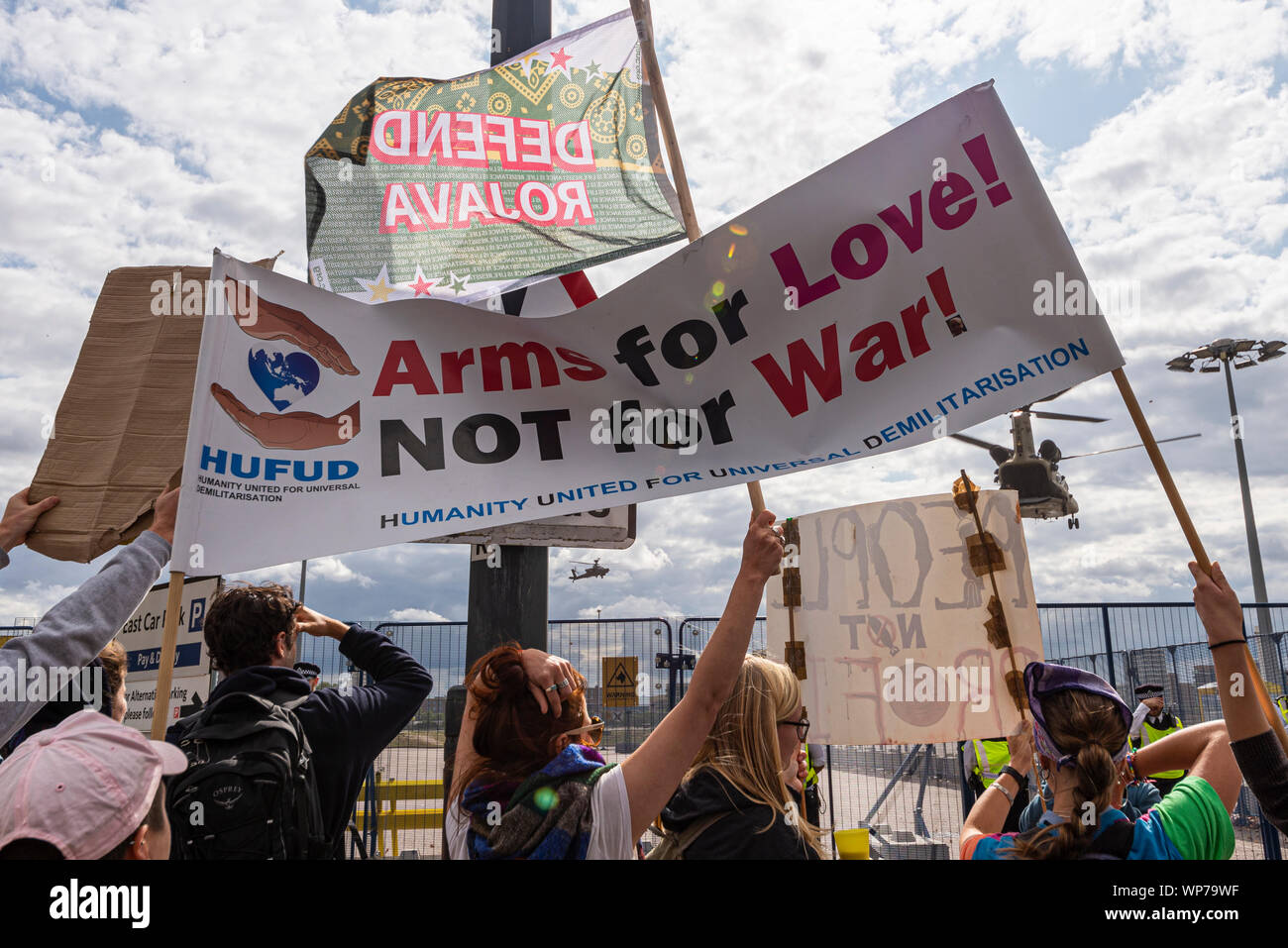 US-Armee Chinook Hubschrauber Landung am Defence and Security Equipment International DSEI arme Fair Trade Show, ExCel, London, UK mit den Demonstranten banner Stockfoto