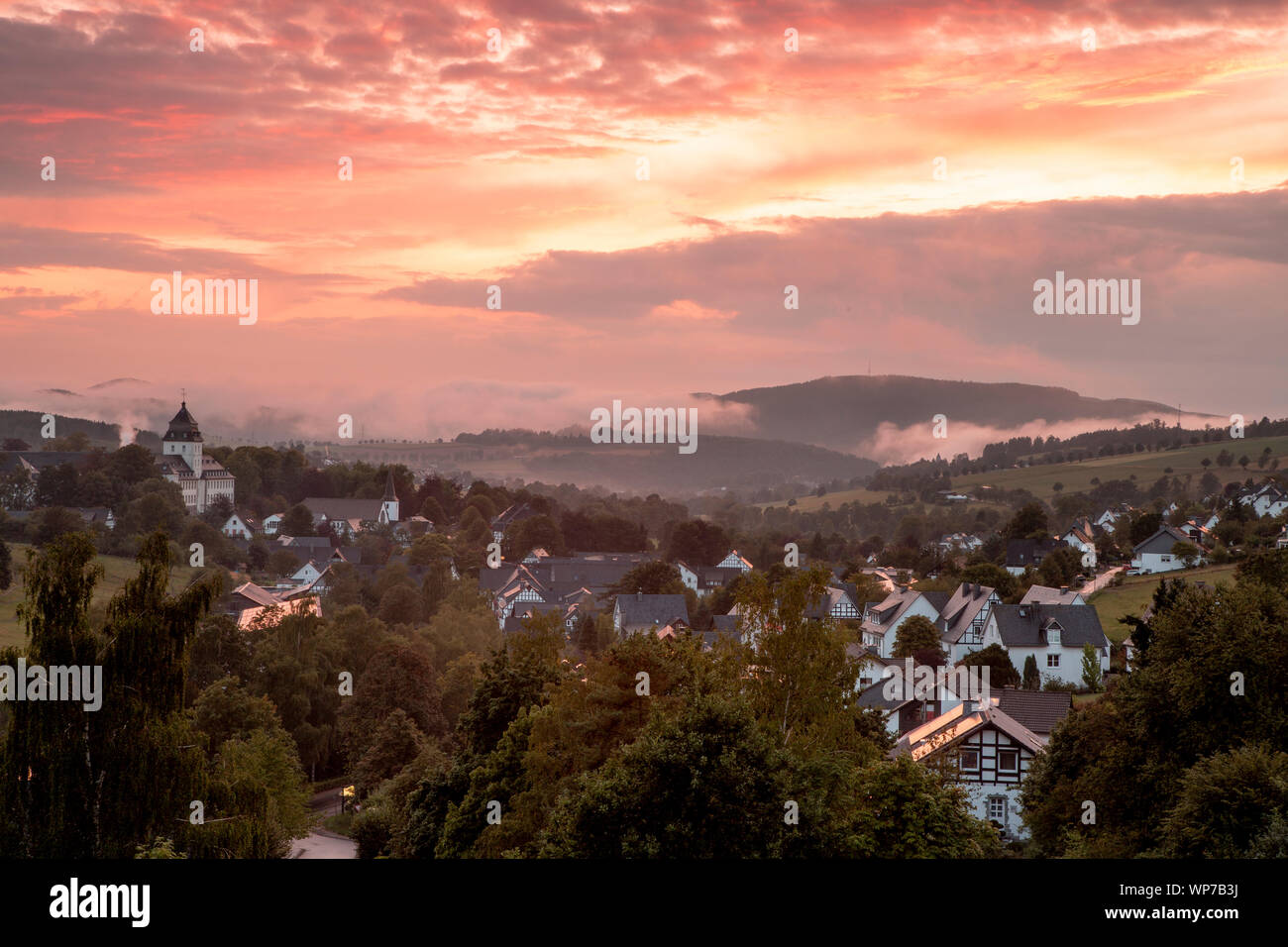 Panoramablick über die bergige Spa Village von Grafschaft im Winter Sport Region Sauerland, Deutschland, während ein farbenfroher Sonnenuntergang Stockfoto