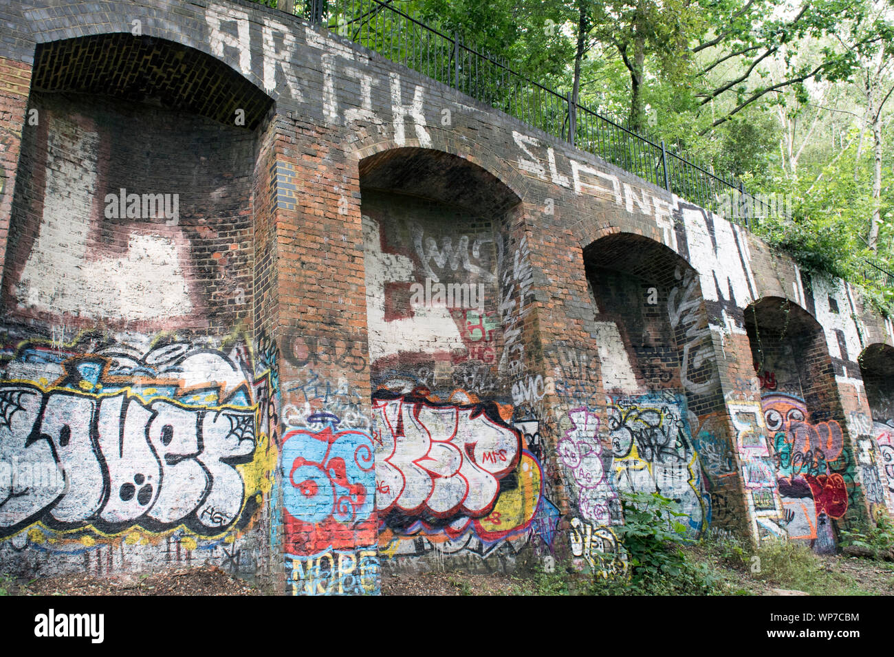Graffiti auf Gemauerten Bahndamm, Parkland, eine stillgelegte Bahnstrecke jetzt ein urban Nature Reserve, Londoner Stadtteil Islington Stockfoto