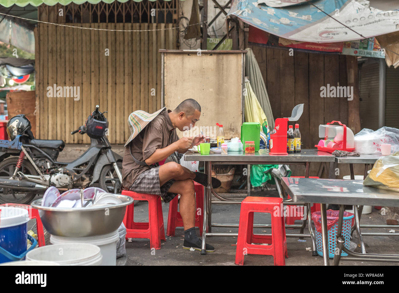 Phnom Penh, Kambodscha - Februar 4, 2019: Ein einsamer asiatischen reisenden isst am Tisch in einem Restaurant. Stockfoto