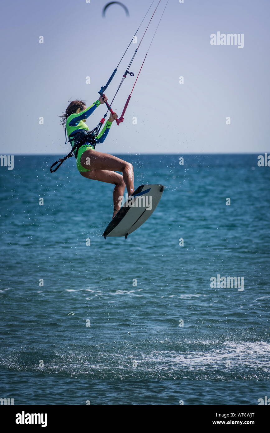 Frau, Kitesurfen, Reiten, Springen und Surfen auf einem Kiteboard auf dem Meer Stockfoto