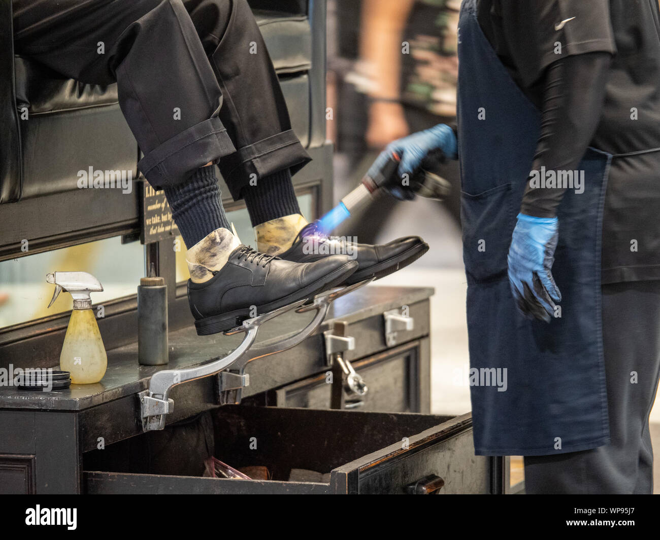 Mann, schwarze Schuhe glänzte und Fertig mit Brenner am Bahnhof Stockfoto