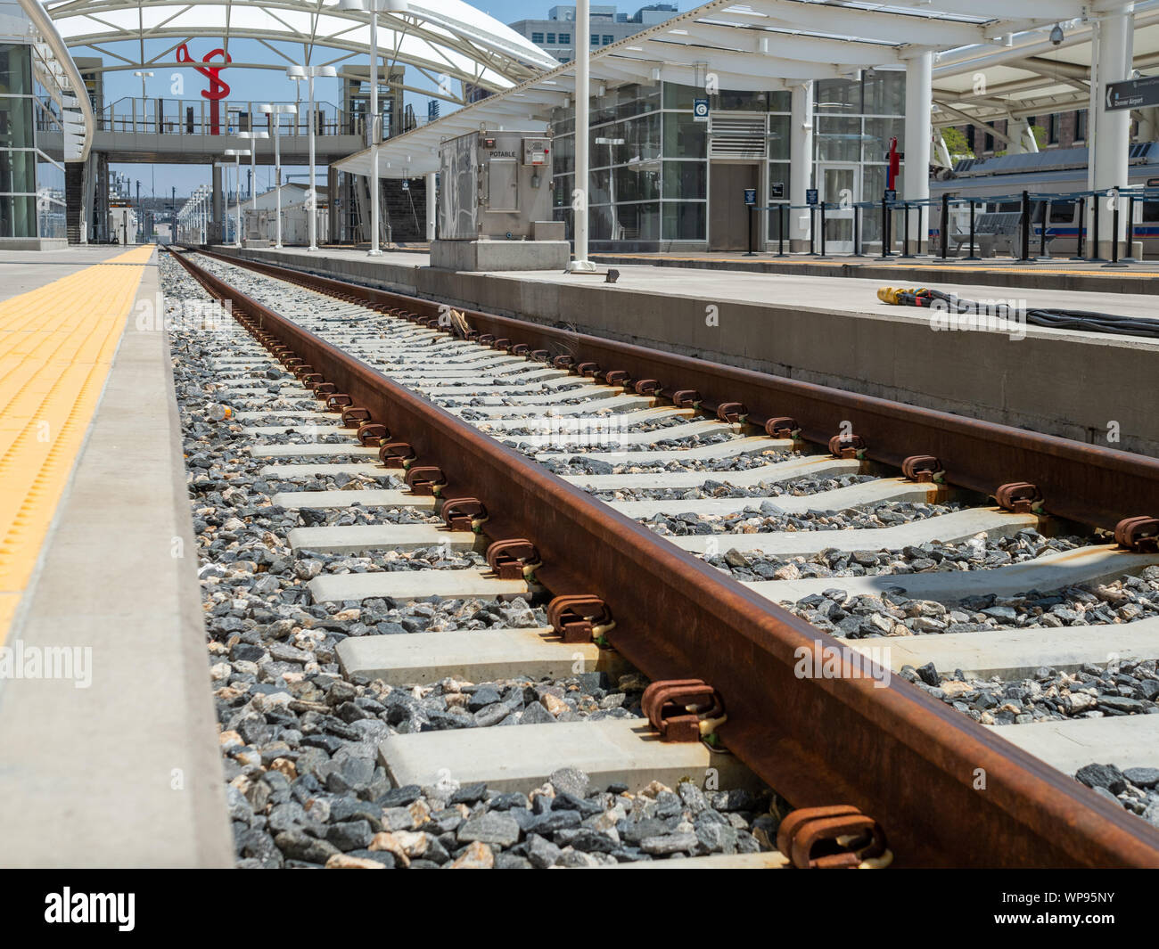 Nahaufnahme der rostigen Eisenbahn reist und Kies in der modernen Bahnhof Stockfoto