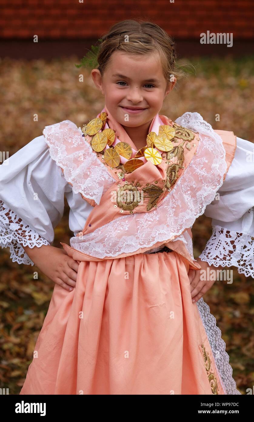 Mädchen gekleidet in traditionelle Kostüme am Thanksgiving Tag in Stitar, Kroatien an die Gemeinde in die Messe gehen Stockfoto