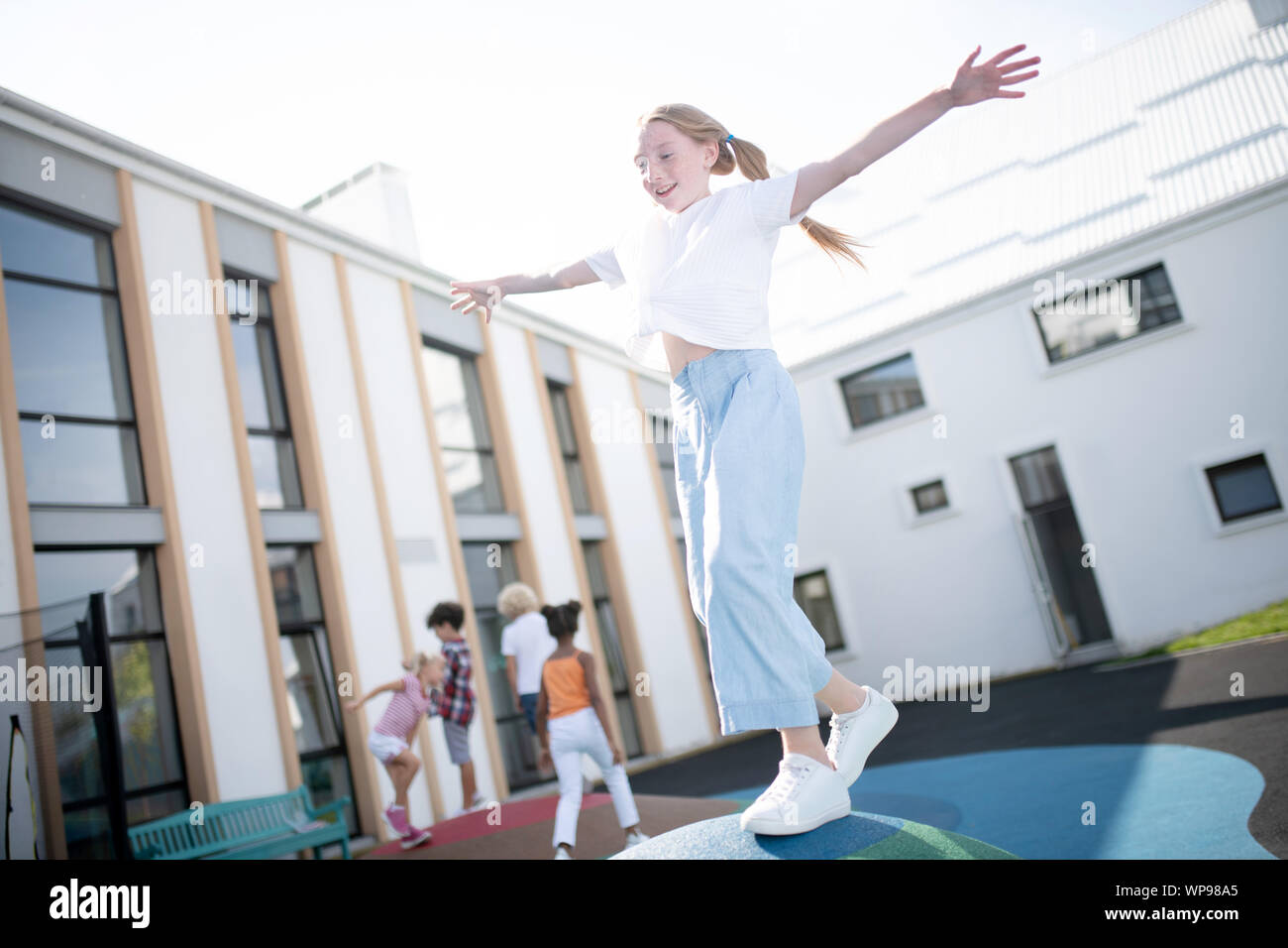 Mädchen mit weißen Turnschuhen außerhalb Spaß an schönen sonnigen Tag Stockfoto